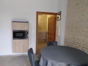 um quarto com uma mesa e cadeiras e uma cozinha em Junior Suite Triple PMR Résidentielle avec cuisine au Manoir de Mathan à Crépon 5mn d'Arromanches et 10 mn de Bayeux em Crépon
