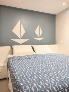 a bedroom with a bed and a wall with two paper birds at Porto Central Residence 01 in Porto De Galinhas +20 photos