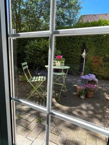 Z okna roztacza się widok na patio ze stołem i krzesłami. w obiekcie Privathotel Bremer w mieście Bergisch Gladbach