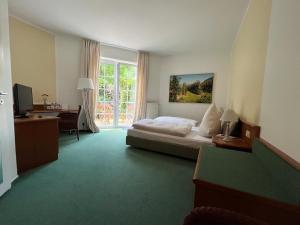 a bedroom with a bed and a desk and a window at Privathotel Bremer in Bergisch Gladbach
