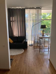 uma sala de estar com um sofá preto e uma mesa em Apartment Dzelzavas 19/3 em Riga