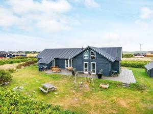 a blue house with a playground in front of it at 18 person holiday home in Harbo re in Harboør