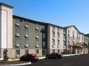 two cars parked in front of a building at Extended Stay America Select Suites - Orlando - Airport in Orlando