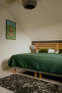 a bedroom with a bed with a green blanket at Lipa pod groniem in Ustroń