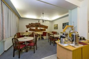 a dining room with tables and chairs and a kitchen at Hotel Rajsky in Český Krumlov