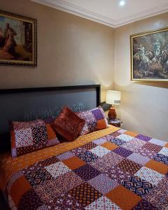 - une chambre avec un lit doté d'une couette colorée dans l'établissement villa Marrakech raja, à Marrakech
