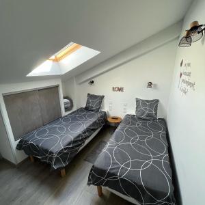 a bedroom with two beds and a skylight at Maison chaleureuse avec terrasse privative proche de la gare in Rochefort