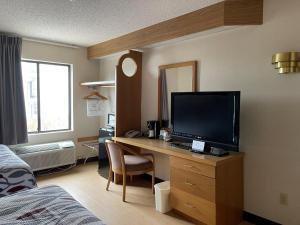 a room with a desk with a television and a bed at Red Roof Inn Branson in Branson