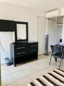 a room with a dresser with a mirror and a chair at Hotel Cascada in Cuautla Morelos