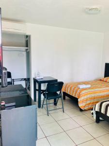 um quarto com uma cama e uma secretária e uma cama e uma mesa em Hotel Cascada em Cuautla Morelos