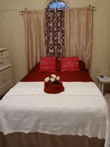 1 dormitorio con 1 cama grande con sábanas rojas y blancas en Inviting 2-Bed House in Fair Prospect, en Port Antonio