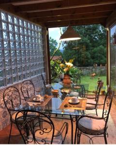 a table and chairs on a patio with a view of a yard at Posada de Villacarriedo in Villacarriedo
