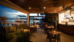 um restaurante com mesas e cadeiras e um barco em Divers Paradise Boutique Hotel em Bocas Town