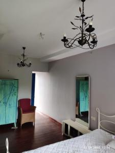 1 dormitorio con 1 cama, 1 silla y 1 lámpara de araña en Gusthouse Shekvetili AE en Shekhvetili