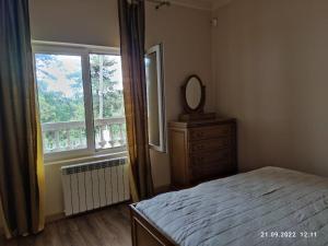 1 dormitorio con cama, espejo y ventana en Gusthouse Shekvetili AE en Shekhvetili