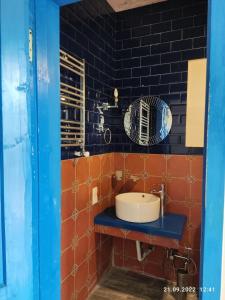 Łazienka z umywalką i ścianą wyłożoną czarnymi kafelkami w obiekcie Gusthouse Shekvetili AE w mieście Shekhvetili