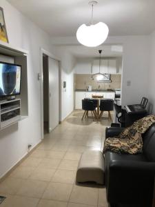 a living room with a couch and a dining room at Departamento PRINGLES - con cochera in La Rioja