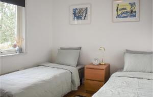 a bedroom with two beds and a nightstand and a window at Awesome Home In Klgerup With Wifi And 2 Bedrooms in Klågerup