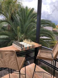 un tablero de ajedrez sobre una mesa en un balcón con 2 sillas en Departamento PRINGLES - con cochera en La Rioja