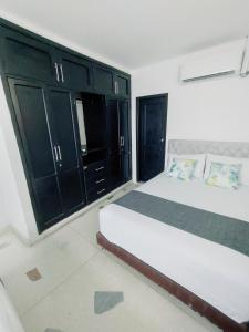 1 dormitorio con 1 cama grande y armarios negros en Hotel Tranvia, en Santa Marta