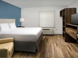 a hotel room with a bed and a television at Extended Stay America Suites - Minneapolis - Airport - Mendota Heights in Mendota Heights