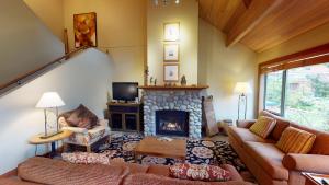a living room with a couch and a fireplace at Montebello by Whistler Premier in Whistler