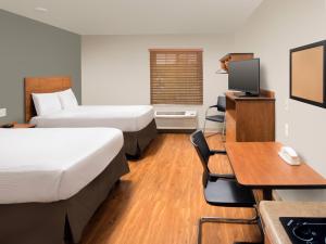 a hotel room with two beds and a desk at Extended Stay America Select Suites - Dayton - Miamisburg in Dayton