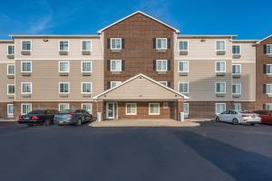 een groot bakstenen gebouw met auto's geparkeerd op een parkeerplaats bij Extended Stay America Select Suites - Dayton - Miamisburg in Dayton