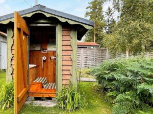 una pequeña casa con un banco en un patio en 4 person holiday home in STORFORS, en Storfors