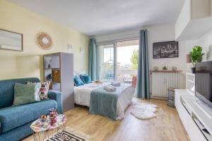 Una sala de estar con una cama y un sofá azul. en Super appartement avec vue sur la Tour Eiffel, en Le Kremlin-Bicêtre