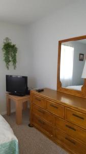 a bedroom with a dresser with a mirror and a tv at 2 Bedroom Condo in Rehoboth Beach w/ New Bed in Rehoboth Beach