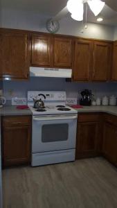 a kitchen with a white stove and wooden cabinets at 2 Bedroom Condo in Rehoboth Beach w/ New Bed in Rehoboth Beach