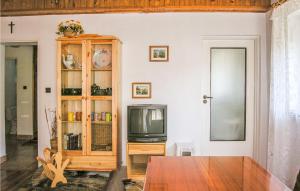 Nice Home In Klodawa With 5 Bedrooms في Santoczno: غرفة معيشة مع تلفزيون وخزانة خشبية