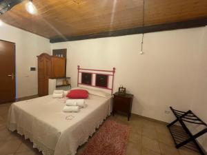 una camera da letto con un letto con cuscini rossi di Casa nel verde ad Albinia