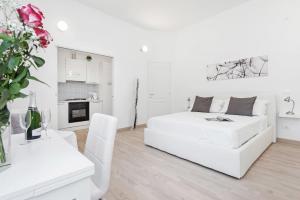 a white living room with a white couch and a table at White Flat Colosseo in Rome