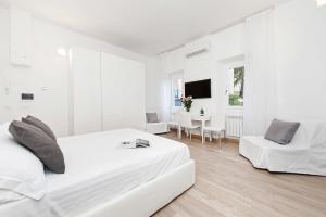 - une chambre blanche avec un lit et une table dans l'établissement White Flat Colosseo, à Rome