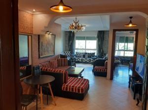 a living room with couches and tables and a living room at StayHere, Nice Apartment with Garden and sea view, 1 min walk From Beach, High-Speed WI-FI in El Jadida