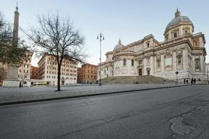 une rue vide devant un grand bâtiment dans l'établissement White Flat Colosseo, à Rome