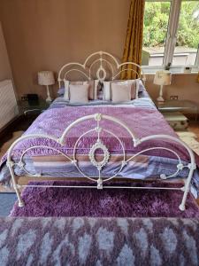 een slaapkamer met een bed met een paars dekbed bij The Goat House 