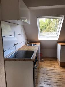 a small kitchen with a sink and a window at Maya's Place in Leverkusen