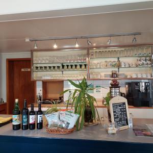 um bar com garrafas de vinho no balcão em B&B Gästehaus Rössli Schwellbrunn em Schwellbrunn