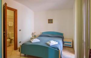 a bedroom with a blue bed and a bathroom at 3 Bedroom Amazing Home In Stintino in Stintino
