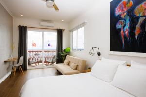 - une chambre avec un lit blanc et un canapé dans l'établissement Divers Paradise Boutique Hotel, à Bocas del Toro