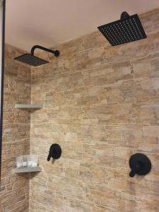 ein Badezimmer mit einer Steinmauer mit Regalen und Lampen in der Unterkunft Casa Lavinia in Casperia