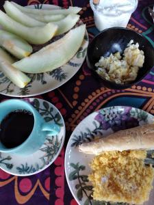 una mesa con platos de comida y una taza de café en POUSADA IPIRÃTÃ - Turismo de Vivência Cultural en Soure