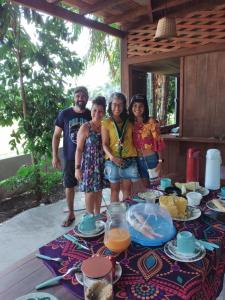 un grupo de personas de pie frente a una mesa en POUSADA IPIRÃTÃ - Turismo de Vivência Cultural en Soure
