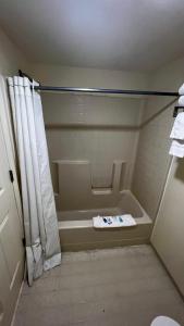 Rodeway Inn - Santa Fe Inn في وينيموكا: حمام مع حوض استحمام وستارة دش