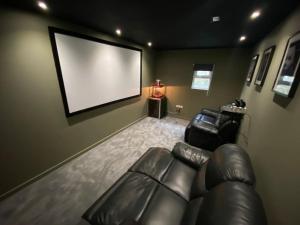 a living room with a couch and a large screen at Jaw-Dropping Beach House In Anglesey in Benllech