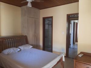 Schlafzimmer mit einem Bett und einem Deckenventilator in der Unterkunft Village Praia do Flamengo frente mar in Salvador