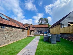 a garden with a table and chairs on a lawn at The Stables in Yate